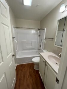 A freshly cleaned bathroom with a white bathtub, toilet, and vanity, showcasing the quality work of Rivas Molina's Cleaning LLC in Dundalk, MD.