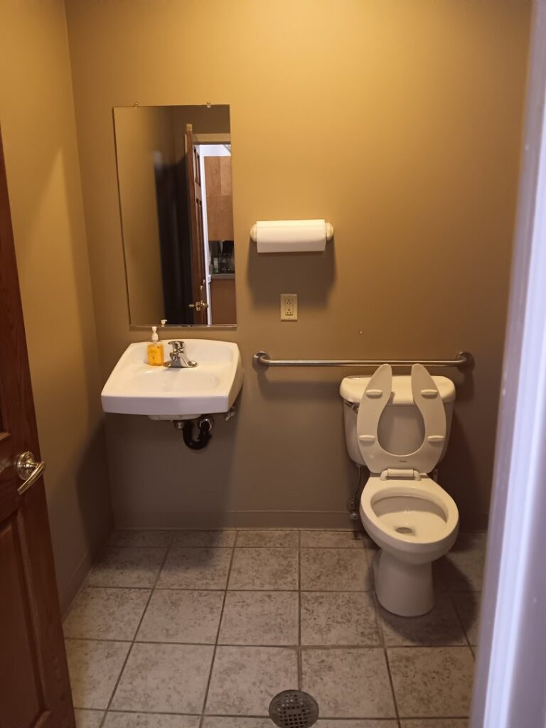 A clean bathroom featuring a toilet and sink, showcasing the thorough cleaning by Faye Cleaning Service LLC in Ankeny, IA.