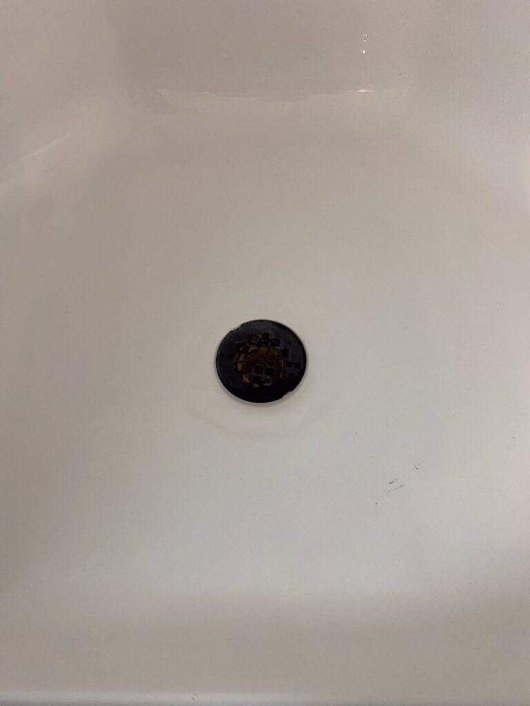 A close-up of a sparkling clean bathtub drain, showing the thorough cleaning by Jolley Services, INC in Bossier City, LA.