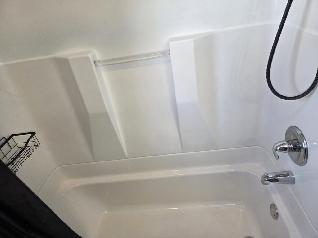 A clean white bathtub and shower area after professional bathroom cleaning by Hm General Cleaning Services in Schenectady, NY