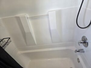 A clean white bathtub and shower area after professional bathroom cleaning by Hm General Cleaning Services in Schenectady, NY