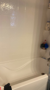 A sparkling clean white bathtub and tiled shower wall, showcasing the quality cleaning by Estela's Cleaning Service's in Lake Elmo, MN.
