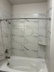 A pristine bathtub and shower with clean tiles, professionally cleaned by Jess Cleaning in San Antonio, TX.