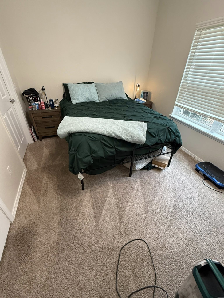 A clean bedroom with a neatly made bed and vacuumed carpet, after house cleaning by WWJM Cleaning Service in Oklahoma City, OK.