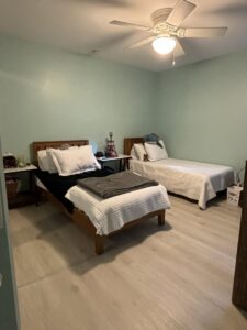 A freshly cleaned and neatly organized bedroom with two beds after a professional house cleaning service by Cleaning Sisters LLC in Richmond, VA.