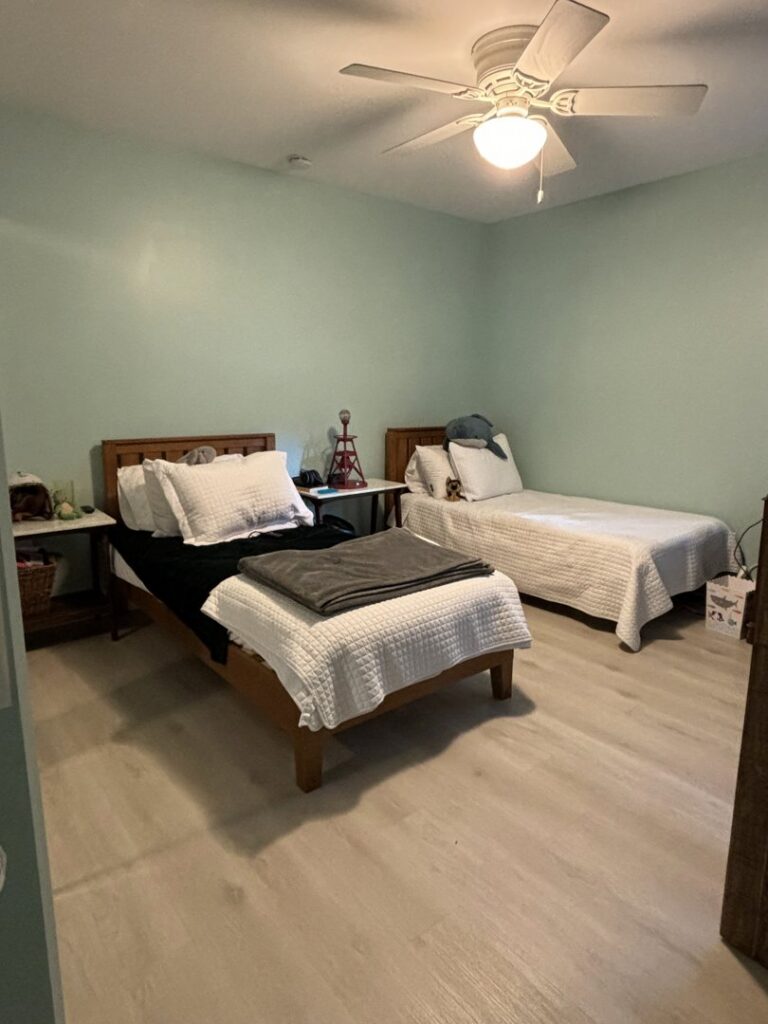 A freshly cleaned and neatly organized bedroom with two beds after a professional house cleaning service by Cleaning Sisters LLC in Richmond, VA.