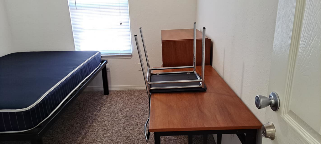 A clean and tidy bedroom with a freshly cleaned carpet, prepared by Solid Rock Cleaning Company LLC in Orlando, FL