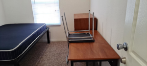 A clean and tidy bedroom with a freshly cleaned carpet, prepared by Solid Rock Cleaning Company LLC in Orlando, FL