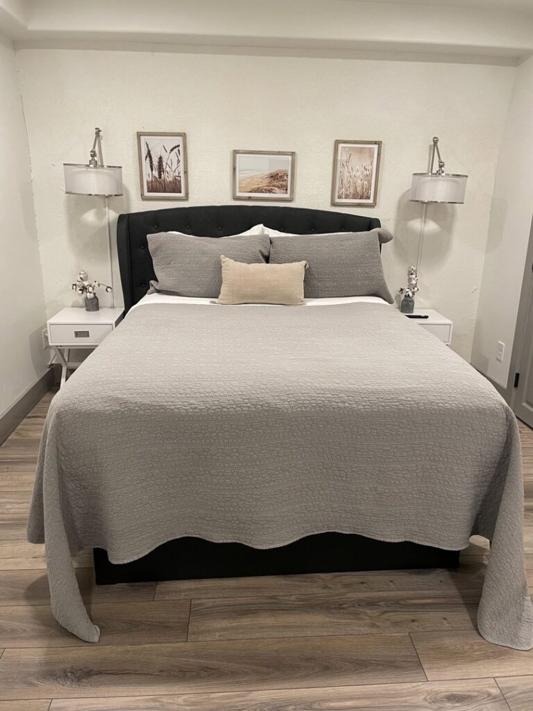 A neatly made bed in a clean bedroom with bedside tables and lamps, demonstrating the thorough house cleaning by Cleans by Roseileen LLC in Louisville, KY.