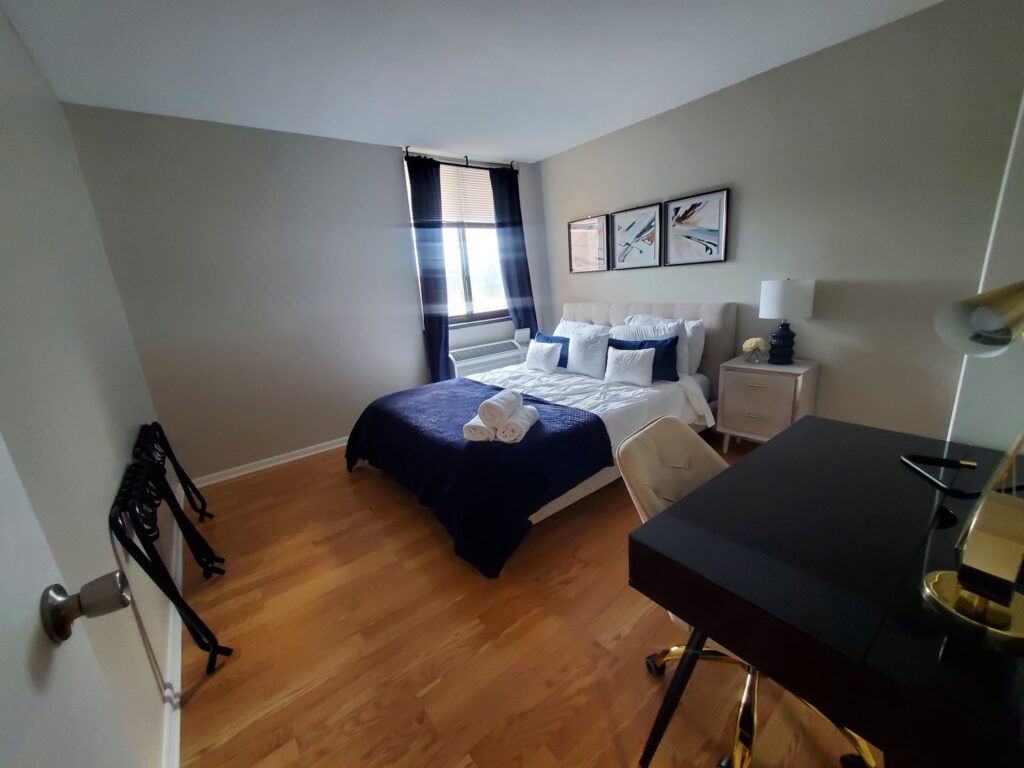A professionally cleaned bedroom with neatly folded white towels on the bed, demonstrating the attention to detail by Maids of Hartford in Hartford, CT.