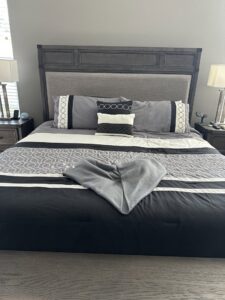 A clean and neatly made bedroom with a heart-folded towel on the bed, a thoughtful detail from Nichole's Cleaning Service in Fort Wayne, IN