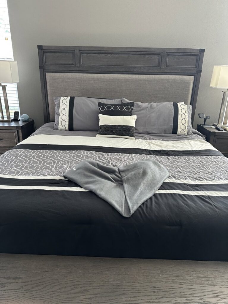 A clean and neatly made bedroom with a heart-folded towel on the bed, a thoughtful detail from Nichole's Cleaning Service in Fort Wayne, IN