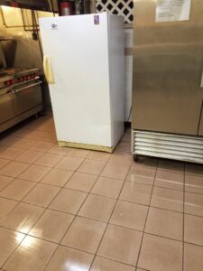 A clean commercial kitchen with tiled floors and stainless steel appliances by Cooper-N-Folks in Philadelphia, PA