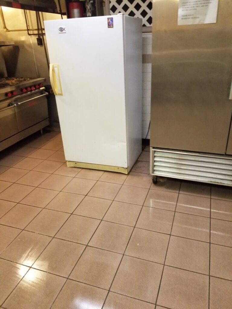 A clean commercial kitchen with tiled floors and stainless steel appliances by Cooper-N-Folks in Philadelphia, PA