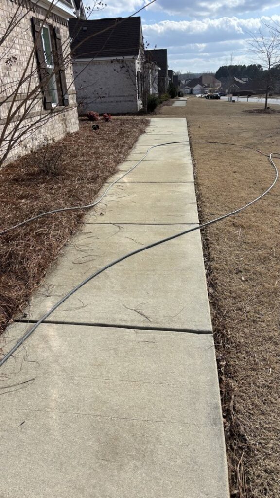 A clean concrete pathway after professional power washing service by Plains Power Washing in Auburn, AL.