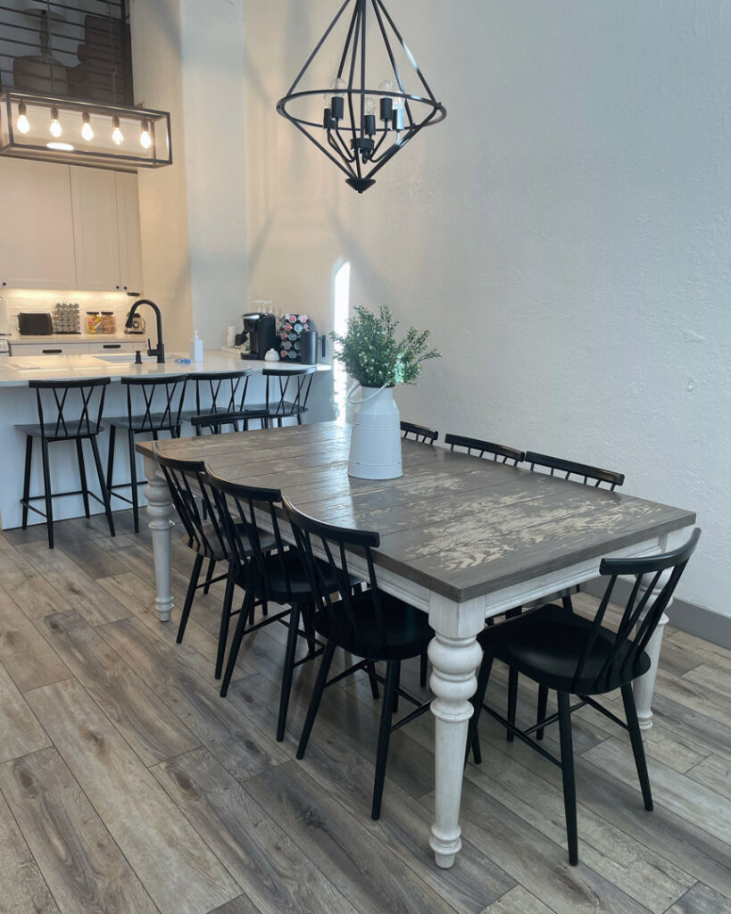 A spacious and clean dining area with a large wooden table and modern chairs, showcasing house cleaning by Cleans by Roseileen LLC in Louisville, KY.