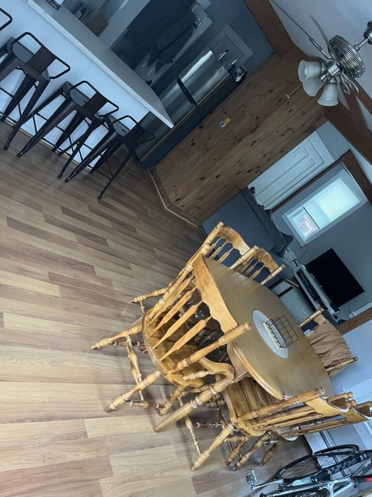 A clean dining area with a wooden table and chairs, and a tidy kitchen counter, reflecting services from Make It Shine in Worcester, MA
