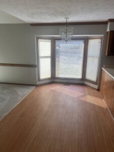 A clean dining area with a bay window and wooden floor, showcasing house cleaning by Time To Shine Cleaning Services in Round Rock, TX.