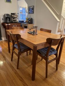 A polished wooden dining table with chairs in a clean home setting, showcasing the attention to detail by Cleans by Roseileen LLC in Louisville, KY.