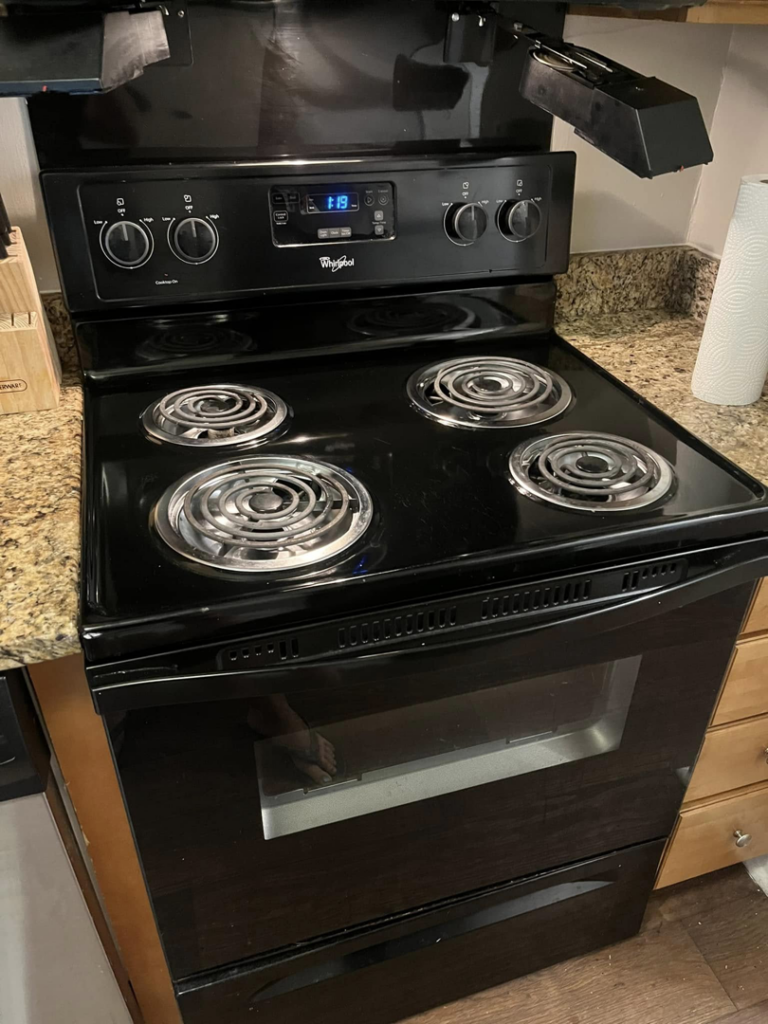 A professionally cleaned black electric stove and oven, looking spotless, by You have it maid in Canton, MI.