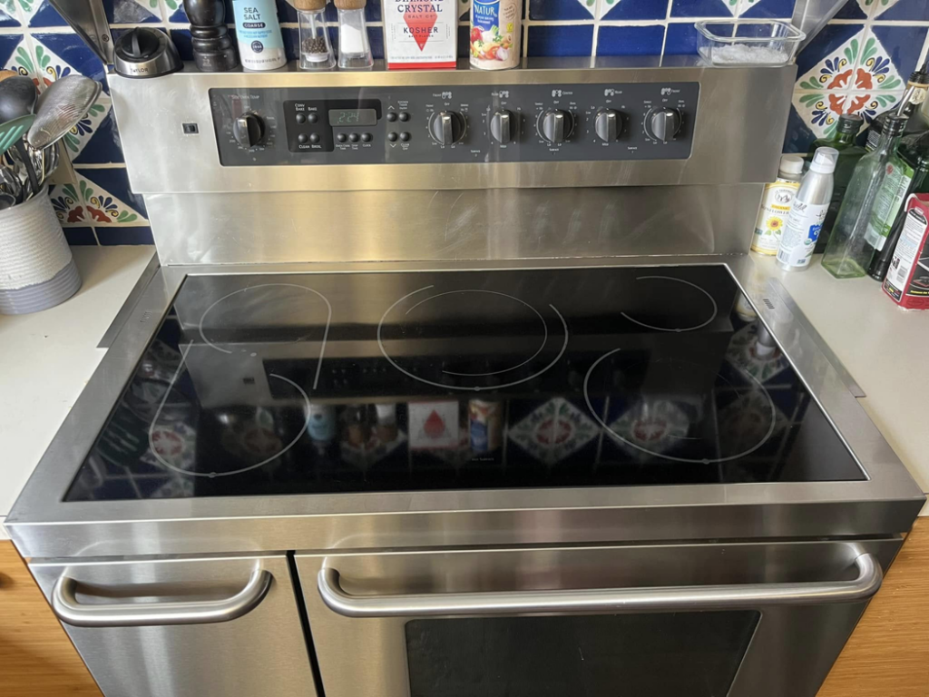 A gleaming clean electric stovetop and oven after house cleaning by Lorena Lyons Cleaning in Concord, NH.