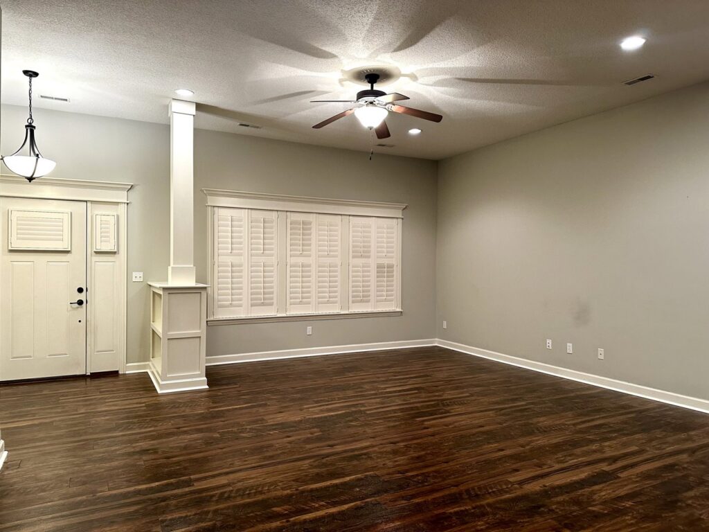 A clean and tidy empty living room with polished hardwood floors, reflecting the quality service of Sudz Up Cleaning Company in Columbia, MO.