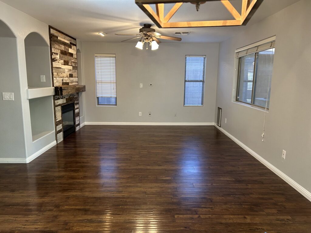 A clean, empty living room with polished wood floors, showcasing a move-out cleaning result by Phoenix Move Out House Cleaning Pros in Chandler, AZ