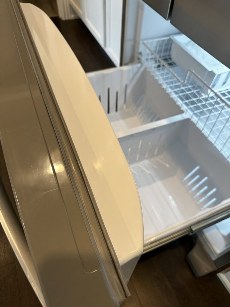 A sparkling clean and empty refrigerator drawer, highlighting the deep cleaning services offered by Sudz Up Cleaning Company in Columbia, MO.