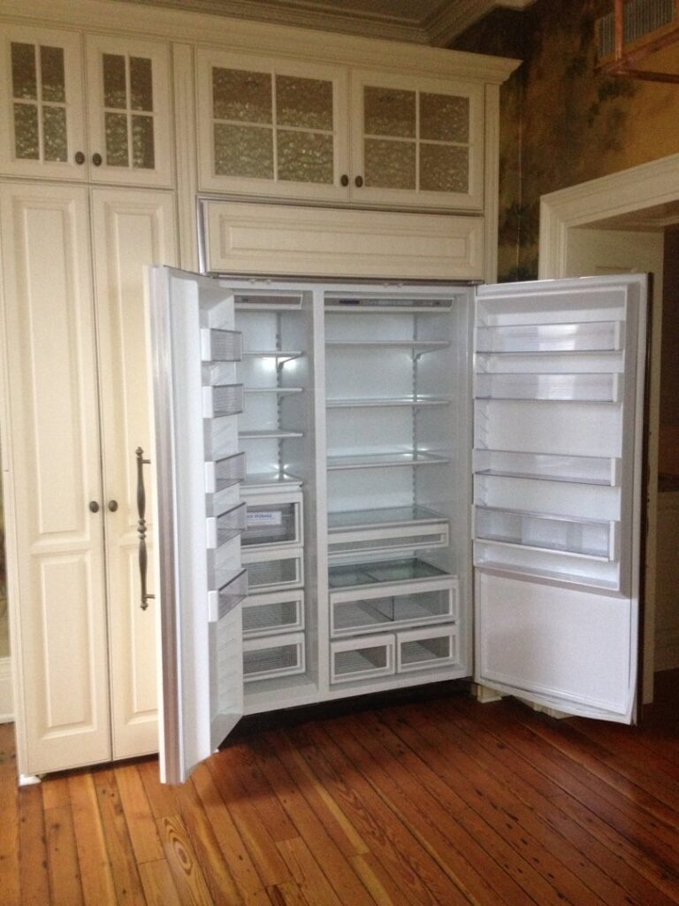 A sparkling clean and empty refrigerator in a kitchen, showcasing the deep cleaning services by Carolina Cleaning Services in Rocky Mount, NC.