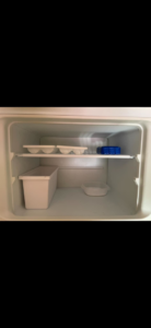 A meticulously cleaned and organized empty top shelf inside a refrigerator by Seabirds Cleaning in Saco, ME.