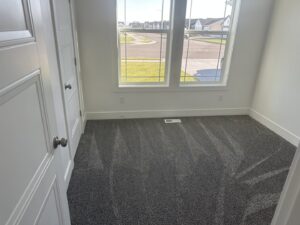 A clean, empty room with freshly vacuumed carpet, showcasing the results of Groove-By-Nature Cleaning in Idaho Falls, ID.