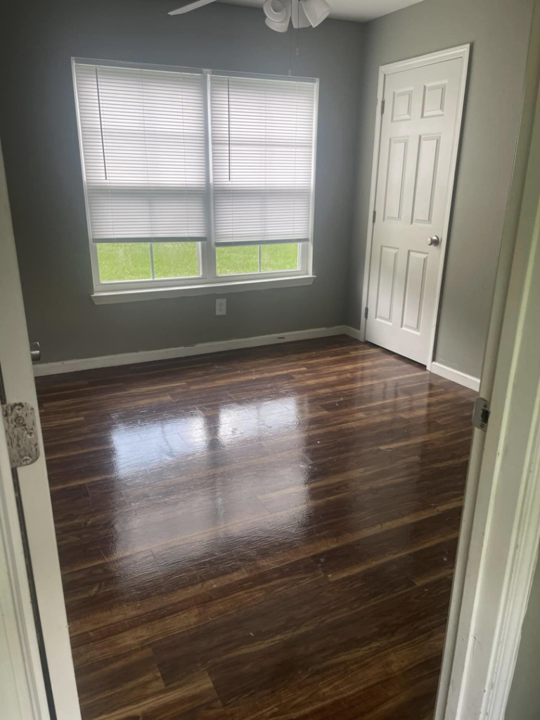 A clean and empty room with shiny wood floors after professional residential cleaning by VM Residential cleaning LLC in Baton Rouge, LA.