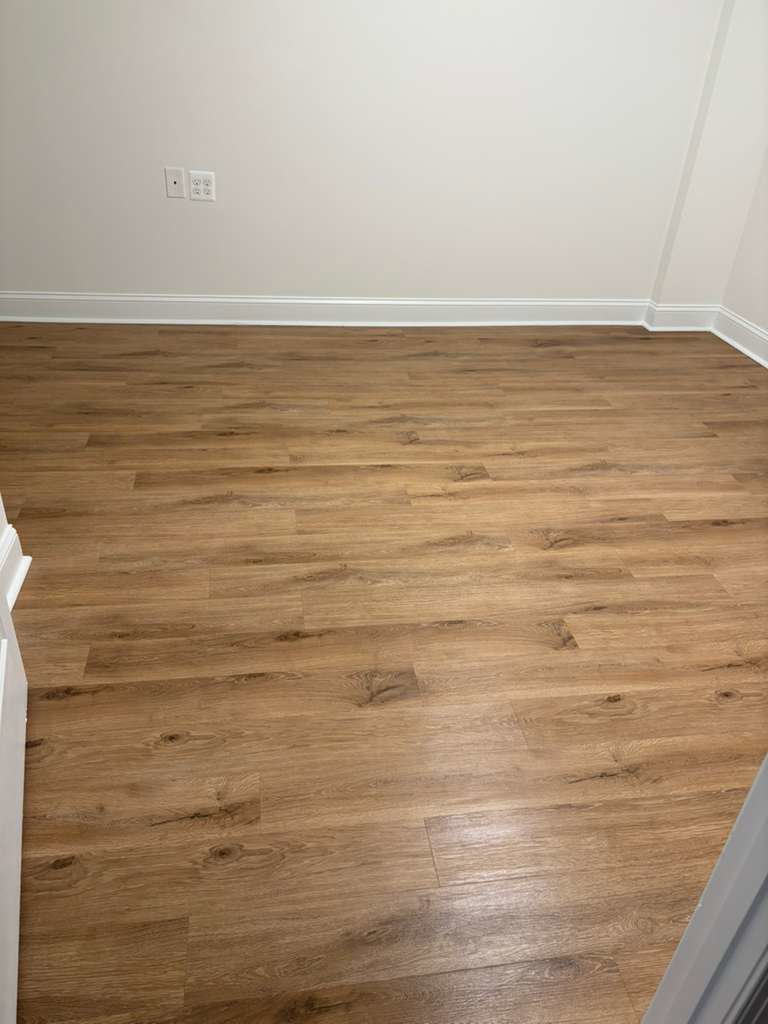 A clean, empty room with pristine hardwood floors, ready for move-in after a professional cleaning by Rivas Molina's Cleaning LLC in Dundalk, MD.