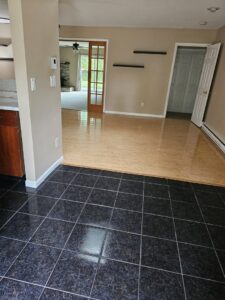 A clean, empty room with shiny wood and tile floors, showcasing a completed house cleaning by Way Too Bright Services LLC in Rockford, IL.