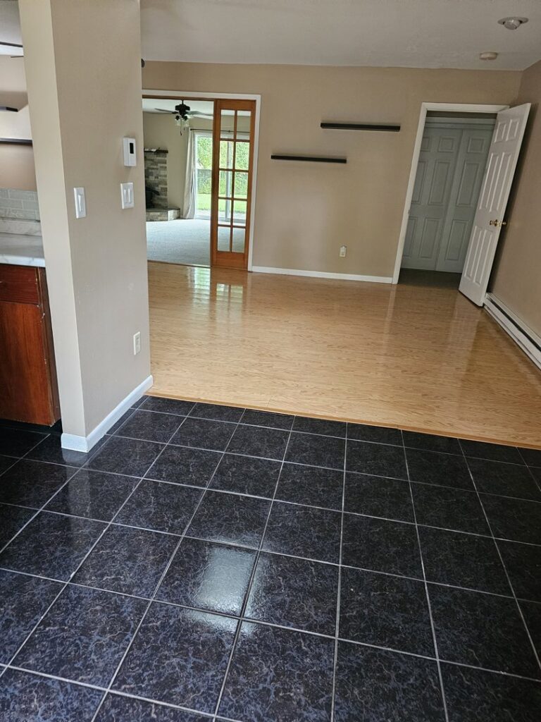 A clean, empty room with shiny wood and tile floors, showcasing a completed house cleaning by Way Too Bright Services LLC in Rockford, IL.