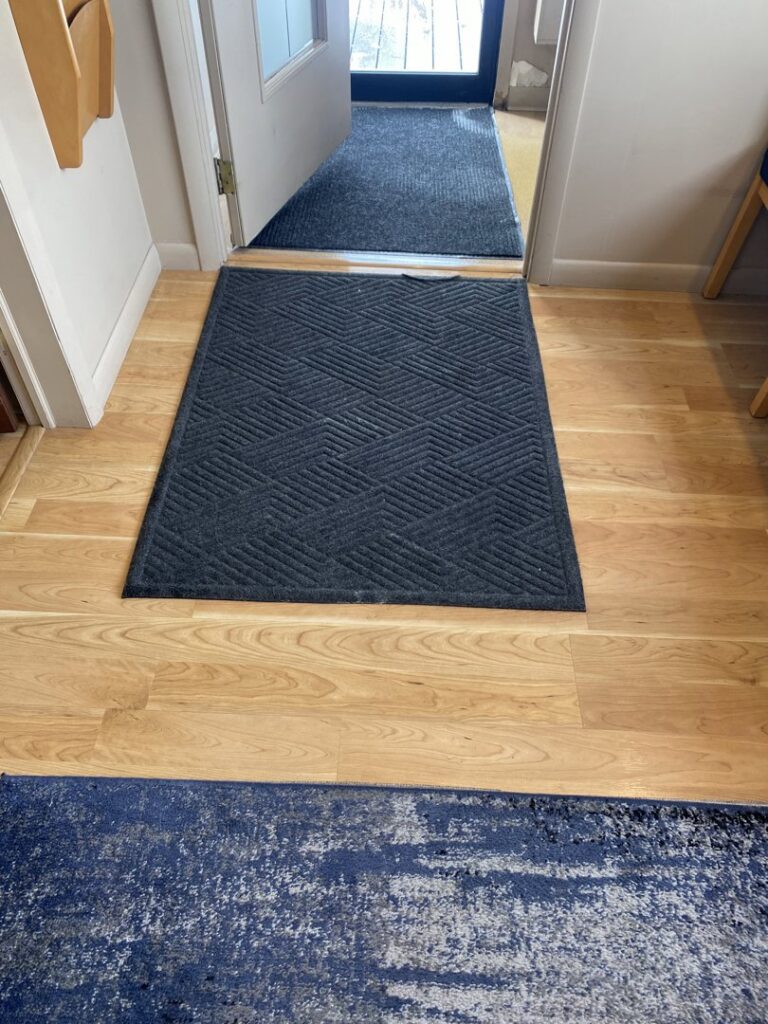 A clean entryway floor with a welcome mat, showcasing professional house cleaning by Cuse Cleaning in Syracuse, NY.