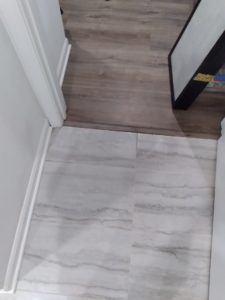 A spotless floor showing a clean transition from wood laminate to tile, cleaned by Squeaky Clean By: Nikki in Chicago, IL.