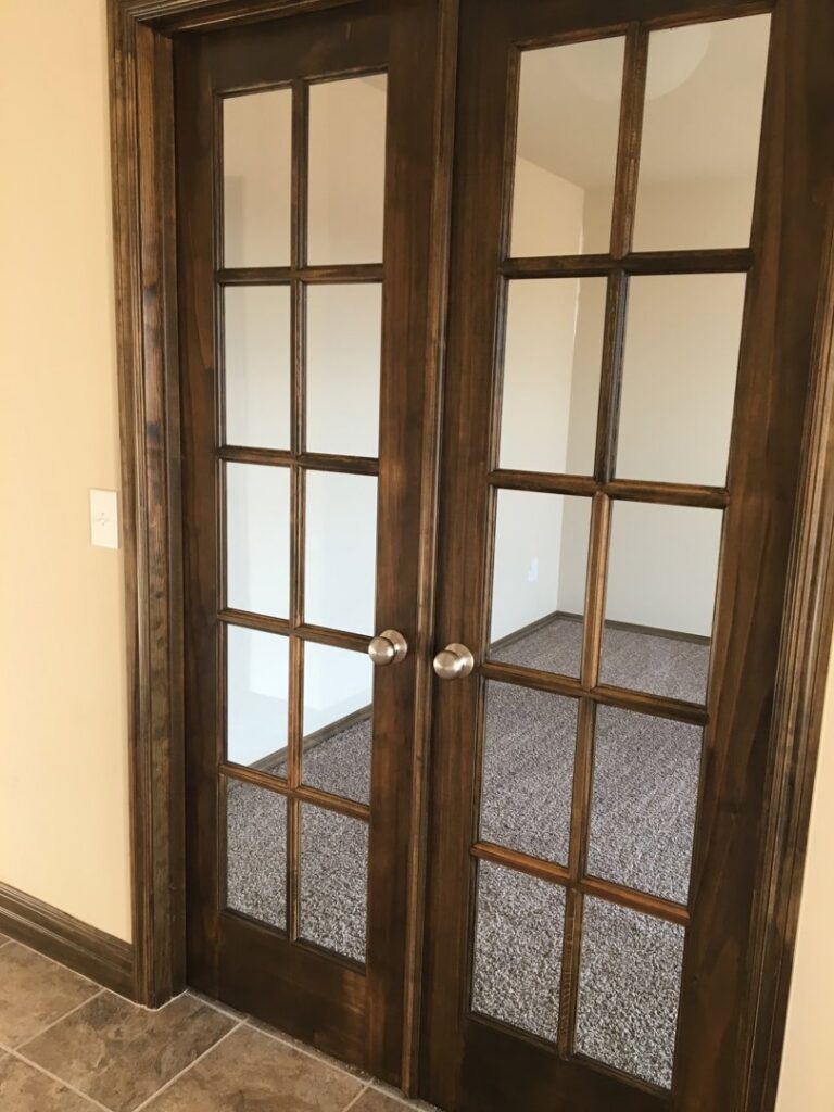Clean French doors leading to an empty, freshly cleaned carpeted room by Pristine Cleaning Concepts in Stillwater, OK.
