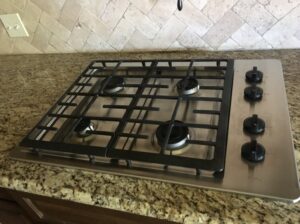 A spotless gas stovetop in a kitchen, professionally cleaned by Magic Maids in Bremen, AL.