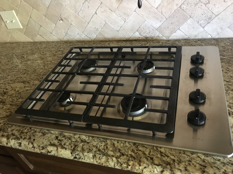 A spotless gas stovetop in a kitchen, professionally cleaned by Magic Maids in Bremen, AL.