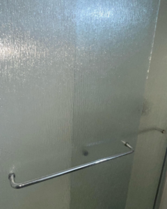 A pristine, clean textured glass shower door with a chrome handle by Stephie's From Dust To Glitter in Detroit, MI.
