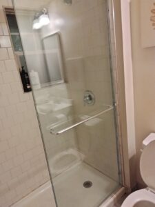 A clean glass shower stall with white tiles, demonstrating the quality bathroom cleaning by Perfection Cleaning in Kansas City, MO.