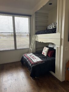 A clean and organized kids' bedroom featuring built-in bunk beds and wooden floors, cleaned by Inspire Clean OKC in Oklahoma City, OK.