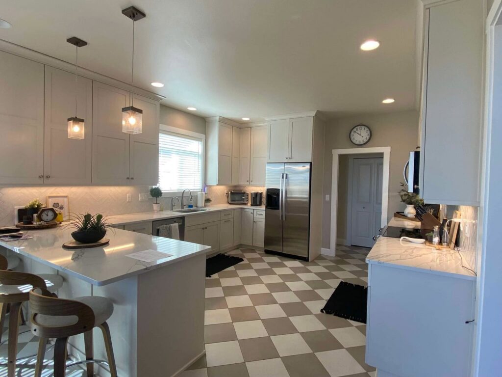 A bright and clean kitchen featuring a checkered floor and stainless steel appliances, maintained by E-N-S Home Cleaning Solutions, LLC in Lewiston, ID.