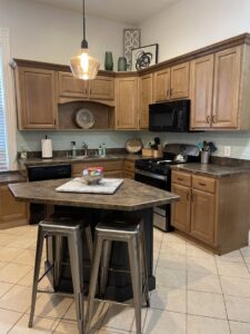 A sparkling clean kitchen with wooden cabinets and an island, showcasing the quality house cleaning by Cleans by Roseileen LLC in Louisville, KY.