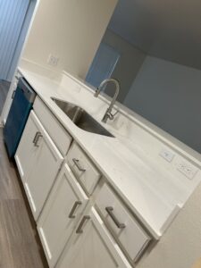 A spotless kitchen counter with a sink and white cabinets, cleaned by Martinez Cleaning Services in Kent, WA