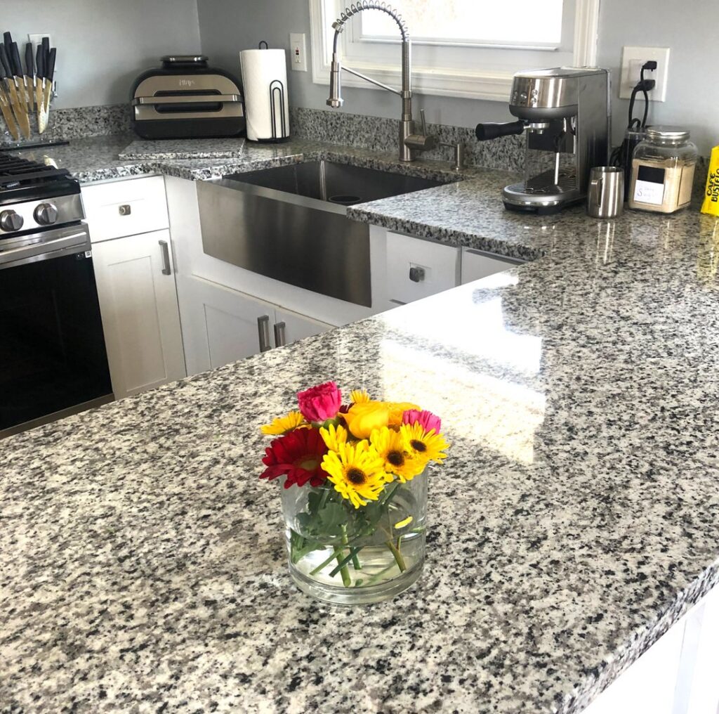 A clean kitchen countertop with a shiny sink and faucet, expertly cleaned by Polished Housekeeping Services in Londonderry, NH.