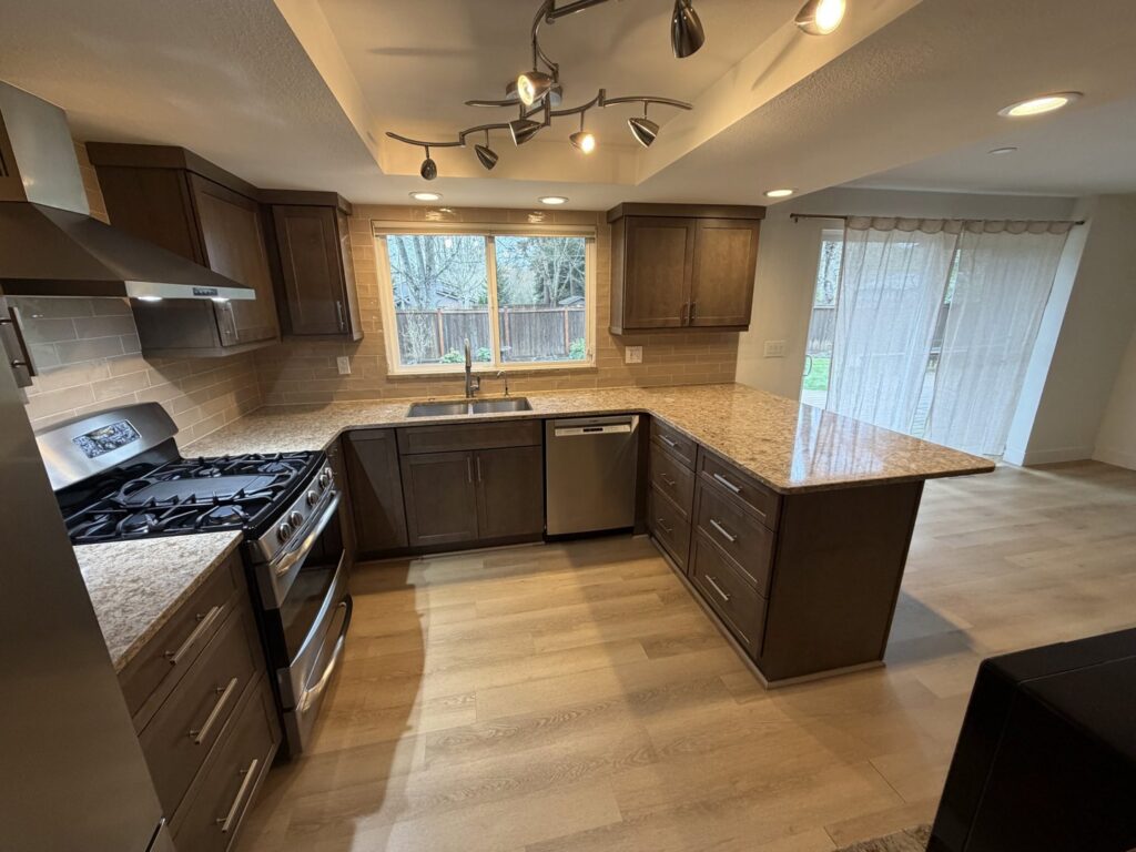 A meticulously cleaned kitchen with dark wood cabinets, granite countertops, and stainless steel appliances, showcasing work by Quesada's cleaning services llc in Seattle, WA.