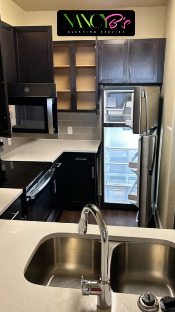 A clean kitchen with an open, empty refrigerator, ready for move-in, by Nancy B's Cleaning Service LLC in Atlanta, GA.