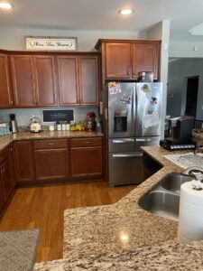 A sparkling clean kitchen with granite countertops and wooden cabinets, cleaned by Five Star Cleaning Service in Pasadena, MD.